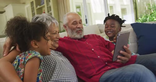 Grandparents and Grandchildren Enjoying Tablet at Home