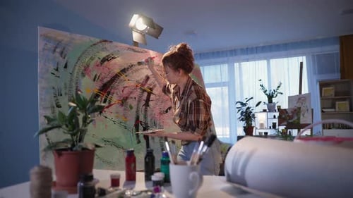 Young Woman Painting Abstract Art in Studio
