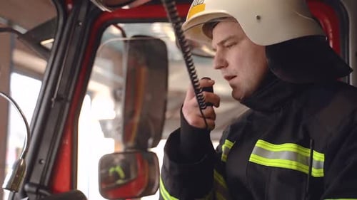 Firefighter Communicating with Walkie Talkie in Firetruck