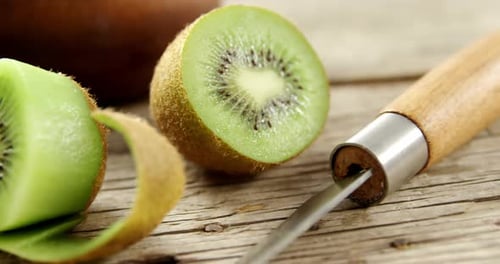 Fresh Kiwi Fruit Slices with Knife on Wood