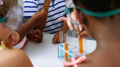 Children Conduct Science Experiment with Colored Liquids