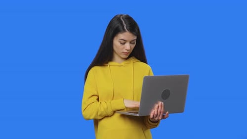 Woman Typing on Laptop in Chroma Key Setting