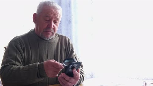 Senior Man Uses Magnifier with His Smartphone