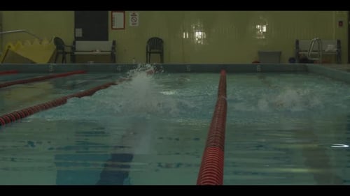 Swimmers Doing Butterfly Stroke in Indoor Pool