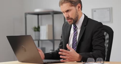 Energetic Businessman in Video Call from Home Office