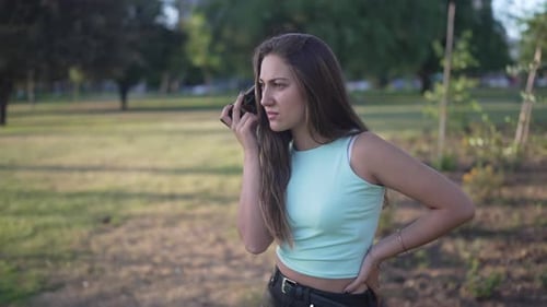 Young Woman Talking on Smartphone in Park