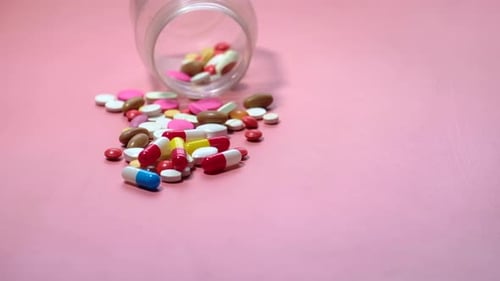Close Up of Colorful Pills Spilling From Container