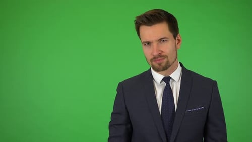 A Young Businessman Shows a Thumb Down To the Camera and Shakes His Head - Green Screen Studio