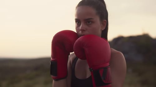 Serious Athlete in Boxing Gloves Trains on Field