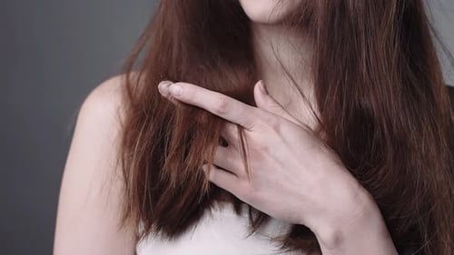 Woman Touching Dry Auburn Hair Close Up