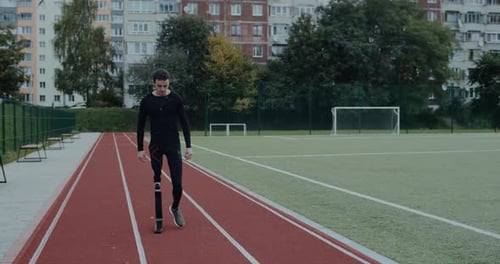 Man with Prosthetic Leg Walking on Running Track