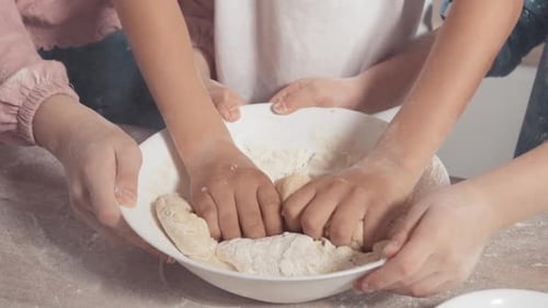 Nahaufnahme Zeitlupe Kinder mischen Teig. Kinderhände und Teig.