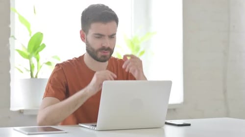 Man Working on Laptop Suffering from Headache