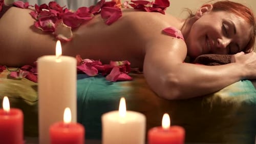 Zufriedene junge Frau entspannt sich nach einer Massage im Spa-Salon, Slider Shot