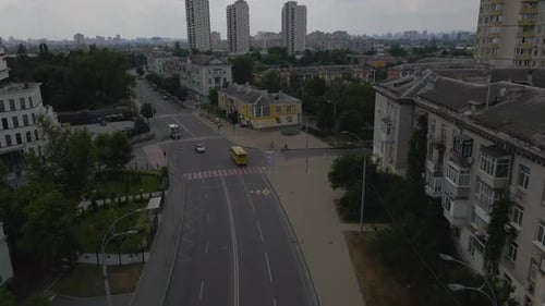Drone is Flying Over the Streets of Kyiv with Traffic on the Road Trees