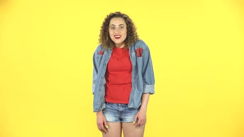 Surprised Girl with Shocked Face Expression on Yellow Background at Studio