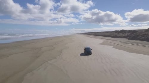 Images aériennes de la conduite d'une voiture sur la plage
