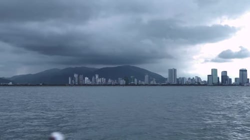 City Skyline on a Gloomy Climate View From the Moving Ferry Boat in Ocean.