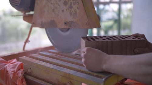 sawing red brick with a circular saw