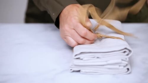 Unfolding Linen Napkins on a Marble Table