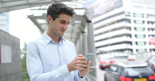 Man Using Mobile Phone at Urban Bus Stop