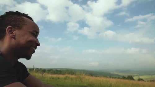 Happy African Guy Sitting at Top of Mountain After Trainings