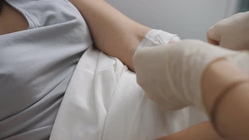Nurse Putting a Drip Into the Catheter Lying Patients Close-up
