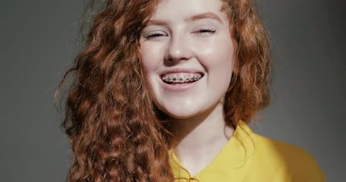 Smiling Young Woman with Red Hair and Braces