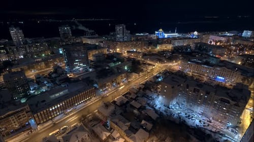 Schöne Nachtsicht auf die Stadt im Winter, Autos bewegen sich, Lichter in Fenstern
