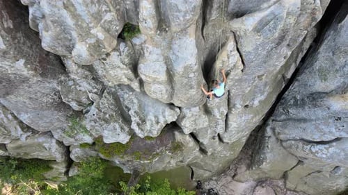 Young Child Boy Descending Down Steep Wall of Rocky Mountain