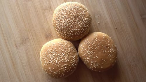 Burger Buns with Sesame Seeds on Wood Surface