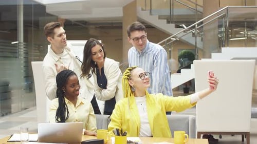 Happy Cheerful Colleagues Making Selfie with the Sell Phone. Office Interior