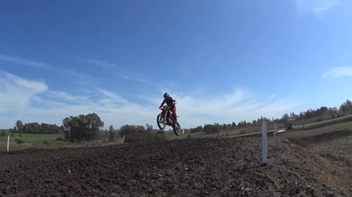 Dirtbike Rider Jumps on Rural Track