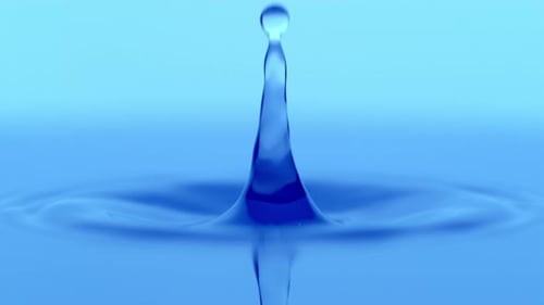 Water Drop Creates Ripples in Blue Liquid