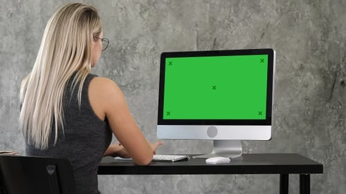 Young business woman working in office interior on pc