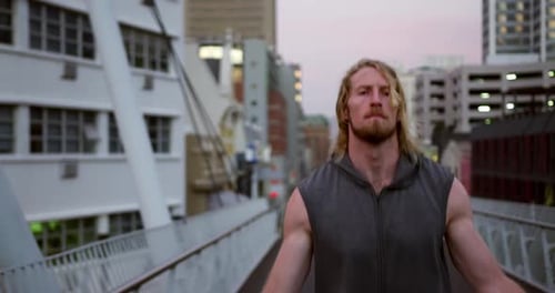 Sporty Caucasian man training on a bridge