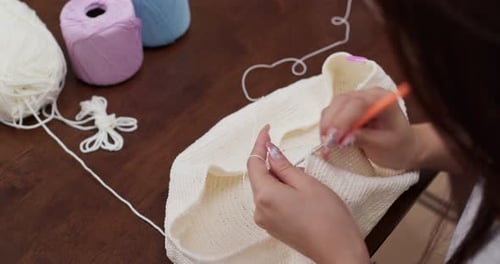 Hands Crochet with Cream Yarn at Table