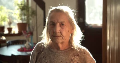 an Elderly Adult Grandmother Looks Into the Camera