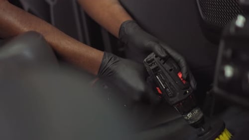 Professional Cleans Car Interior with Drill Brush
