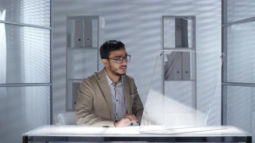 Arabischer Geschäftsmann arbeitet im Büro an futuristischem transparentem Computer