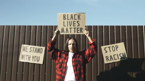 Young Adult Protests Against Racism with Signs