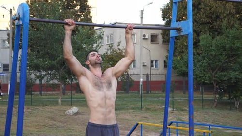 Muscular Man Doing Pull-ups at Outdoor Gym