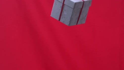 Christmas present dropping on red background