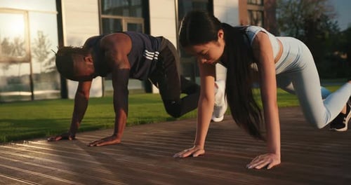 Athletic Couple Doing Mountain Climber Exercise Outdoors