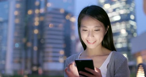 Woman use of smart phone at outdoor in the evening
