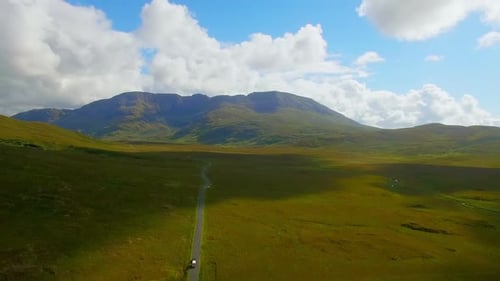 Vehicle moving on road passing through green landscape 4k