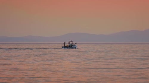 Fishing Boat Sailing on Calm Ocean at Sunset