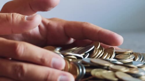 Hands Gathering and Dropping Gold and Silver Coins