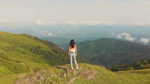 Woman Enjoying Mountain Vista on Grassy Hilltop