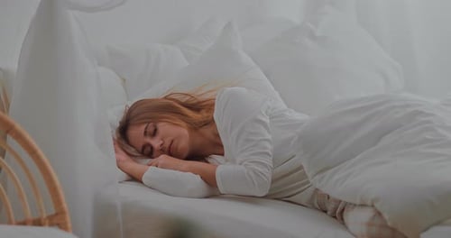 Woman Wakes up and Stretches in Bed
